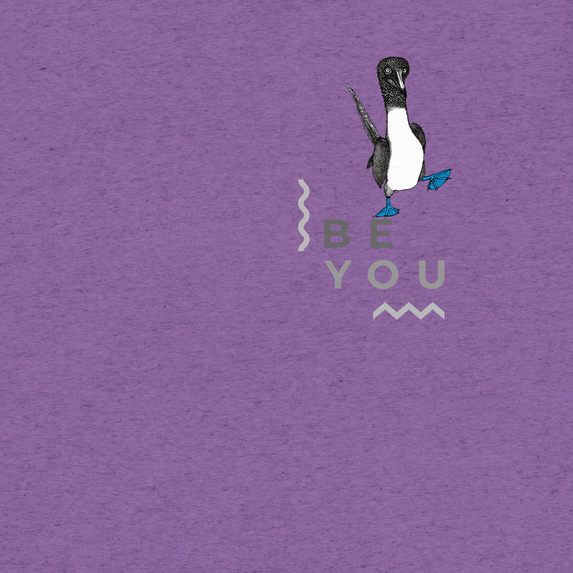 Purple triblend t-shirt featuring Be You in bold text with a detailed illustration of a blue-footed booby. Soft, lightweight fabric with a comfortable fit, showcasing lifelike textures in the artwork.